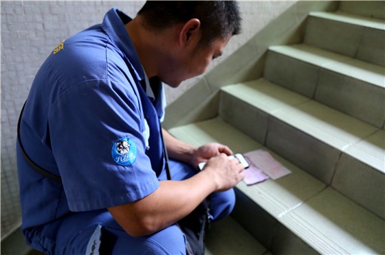 客戶還是沒有到，家具安裝謝師傅蹲在門口等，一邊等一邊處理今天要去的下一家客戶的資料