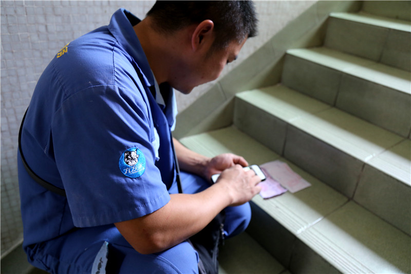 客戶還是沒有到，家具安裝謝師傅蹲在門口等，一邊等一邊處理今天要去的下一家客戶的資料