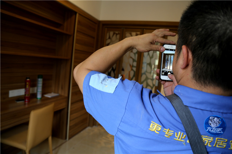 謝師傅看著安裝好的家具，拍下照片