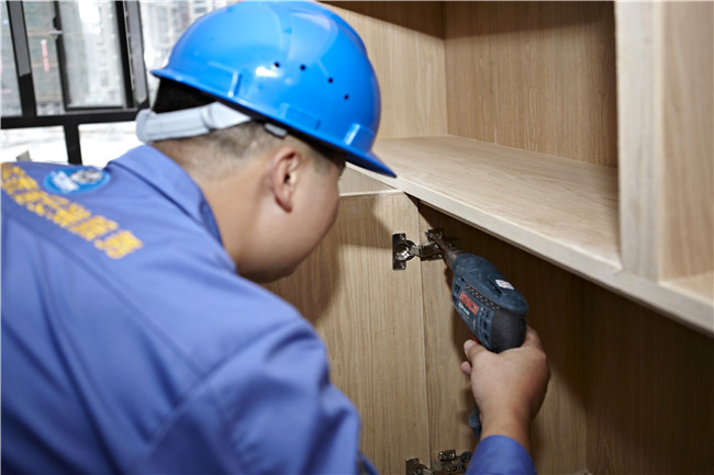 左右手家具安裝工正在給安裝衣柜門(mén)